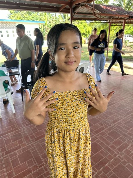 Girl at the children's home showing off her freshly painted nails.